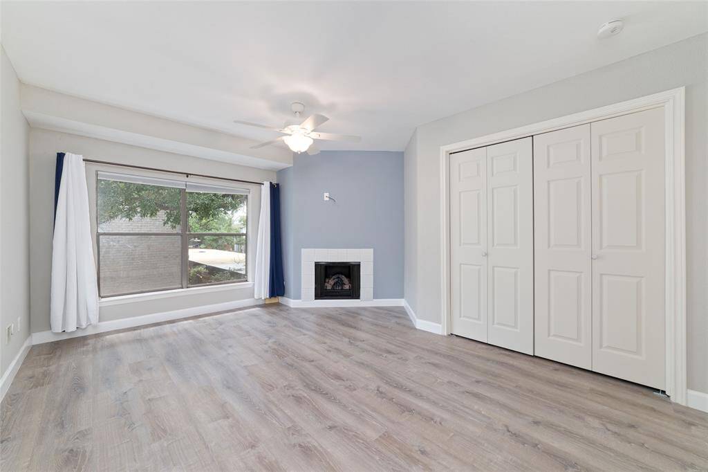 The primary bedroom offers a spacious layout with a cozy fireplace, a large window, and double-door closets for ample storage. Neutral tones throughout make it easy to style the space to your taste.