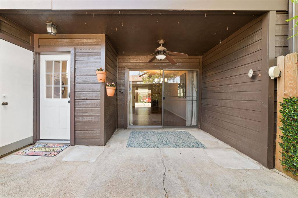 The townhome has a private outdoor patio with a wooden fence and ceiling fan, offering a peaceful and secluded space. It is so gorgeous!