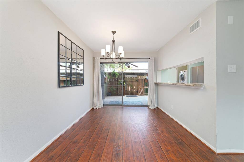 The dining area is filled with natural light, thanks to the large sliding doors that overlook the patio. A pass-through window to the kitchen adds convenience and enhances the open feel of the space.