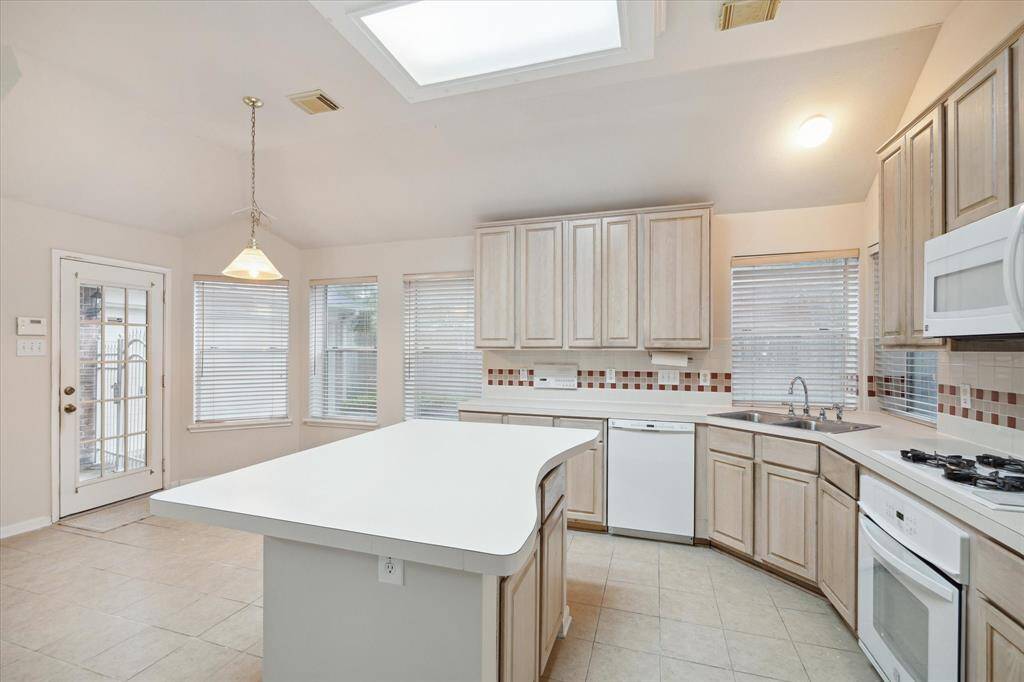 ISLAND KITCHEN WITH TILE FLOORS.