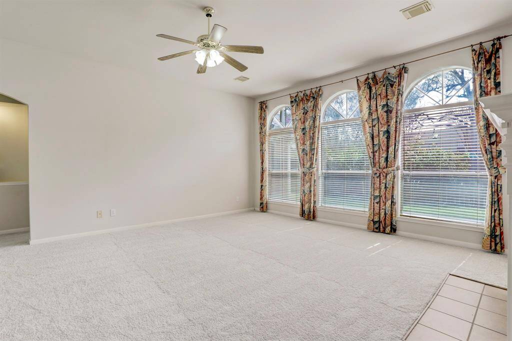 SPACIOUS DEN WITH ARCHED, PORTRAIT WINDOWS PROVIDING PLENTY OF NATURAL LIGHT.