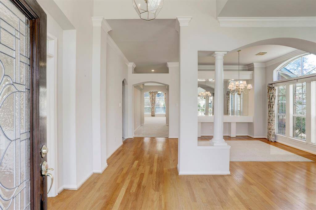 FOYER WITH A DIRECT VIEW OF THE FORMAL LIVING ROOM AND DINING ROOM SEPARATED BY AN ARCHWAY WITH COLUMNS.