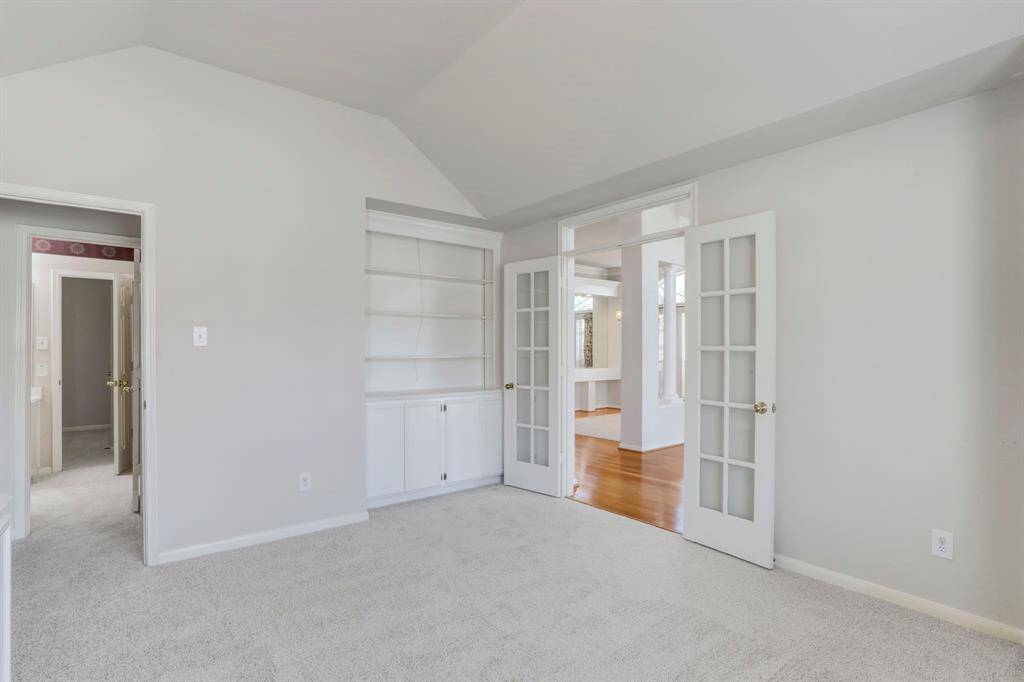 OPPOSITE THE FORMAL LIVING ROOM AND DINING ROOM IS THE OFFICE WITH GLASS FRENCH DOORS.