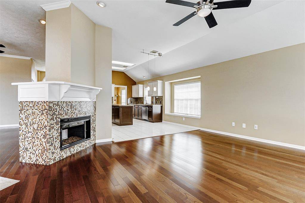 The heart of this room is the gorgeous tiled double-sided fireplace, a beautiful feature that serves as both a visual centerpiece and a source of warmth and ambiance.