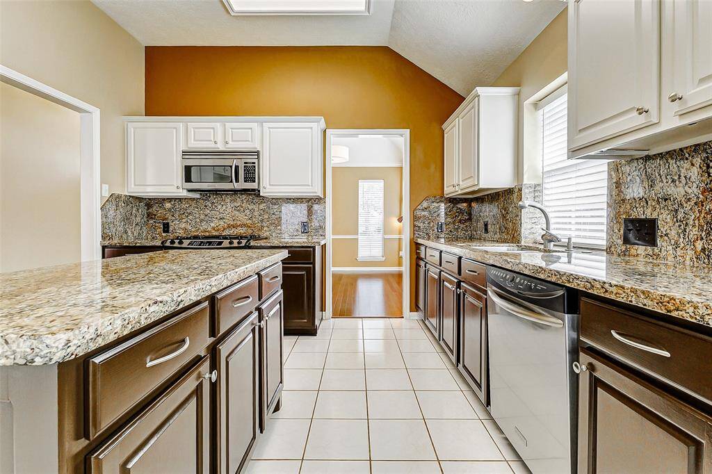 The elegance of granite countertops and backsplash creates a stunning focal point.