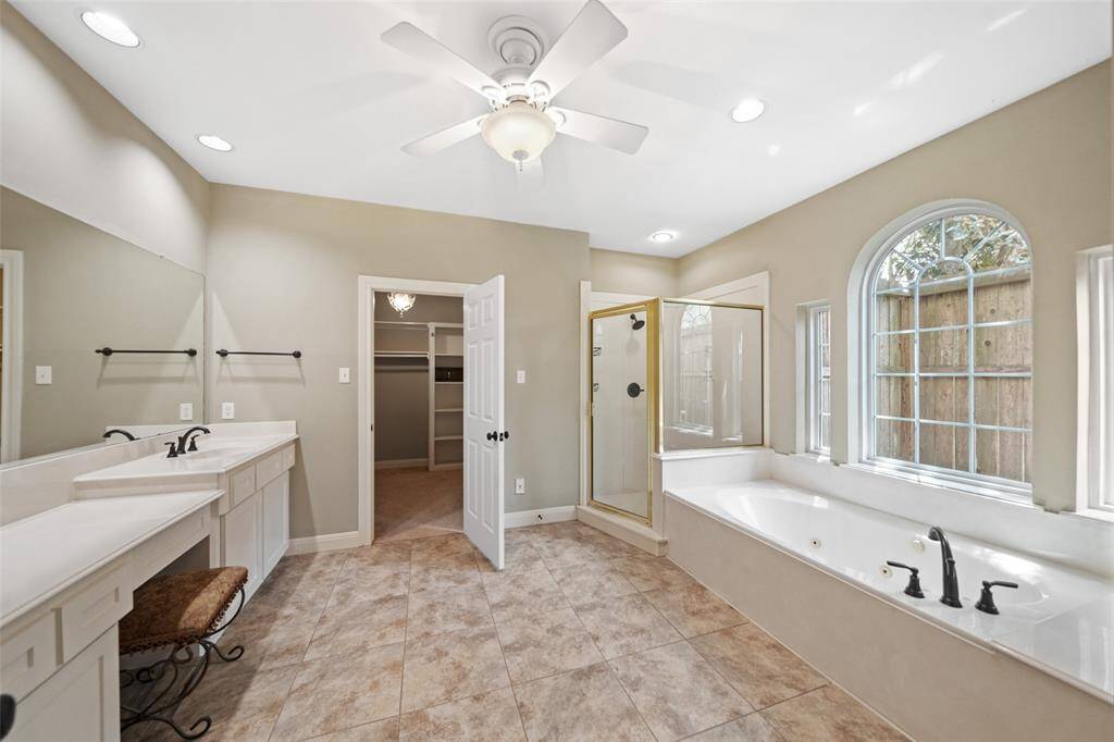 Large primary bathroom with separate shower and a jetted garden tub.