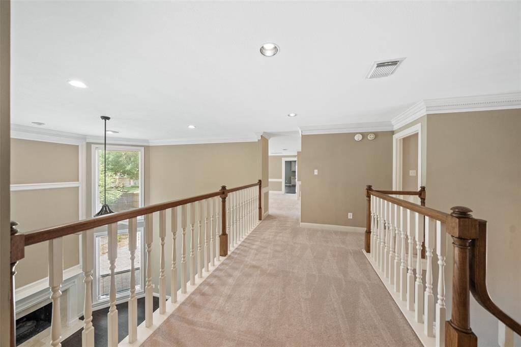 Upstairs walkway opens up to another family room and connects to the large gameroom. To the left the large living room on the 1st floor is pictured.