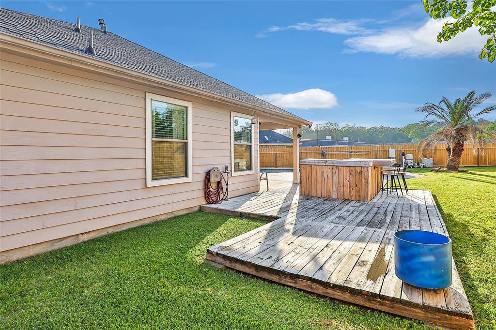 A VIEW OF YOUR DECK AND OUTDOOR BAR.  AND AGAIN YOU'VE GOT ALL THIS LUSH GREEN GRASS.  THERE IS TONS OF SPACE AND THINK OF THE FUN IN THE SUN AND ALL MEMORIES YOU WILL MAKE IN THIS INVITING AND BEAUTIFUL BACKAYARD SPACE.