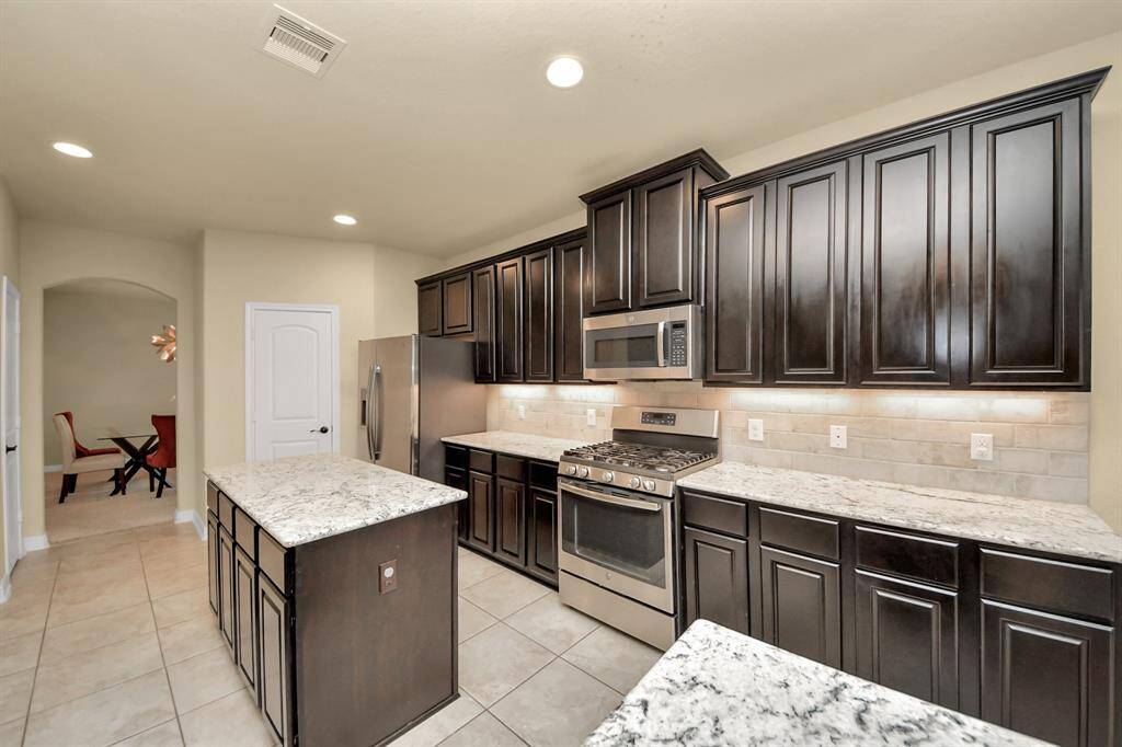 The kitchen has ample storage including a central island with storage.