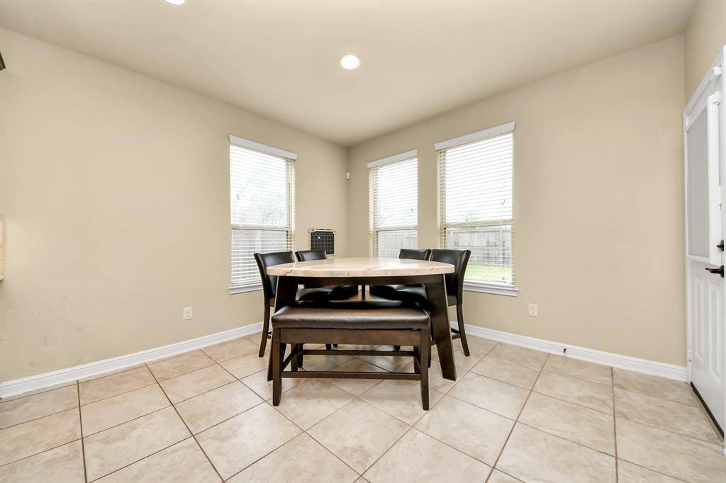 The breakfast room features a bar height table and seating for 6 including a bench and 4 chairs.