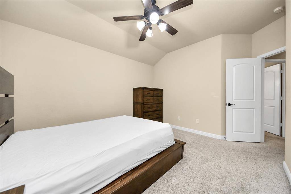 Bedroom #2 features a queen-sized bed with built-in storage, matching dressers, a ceiling fan and a large window for natural light.