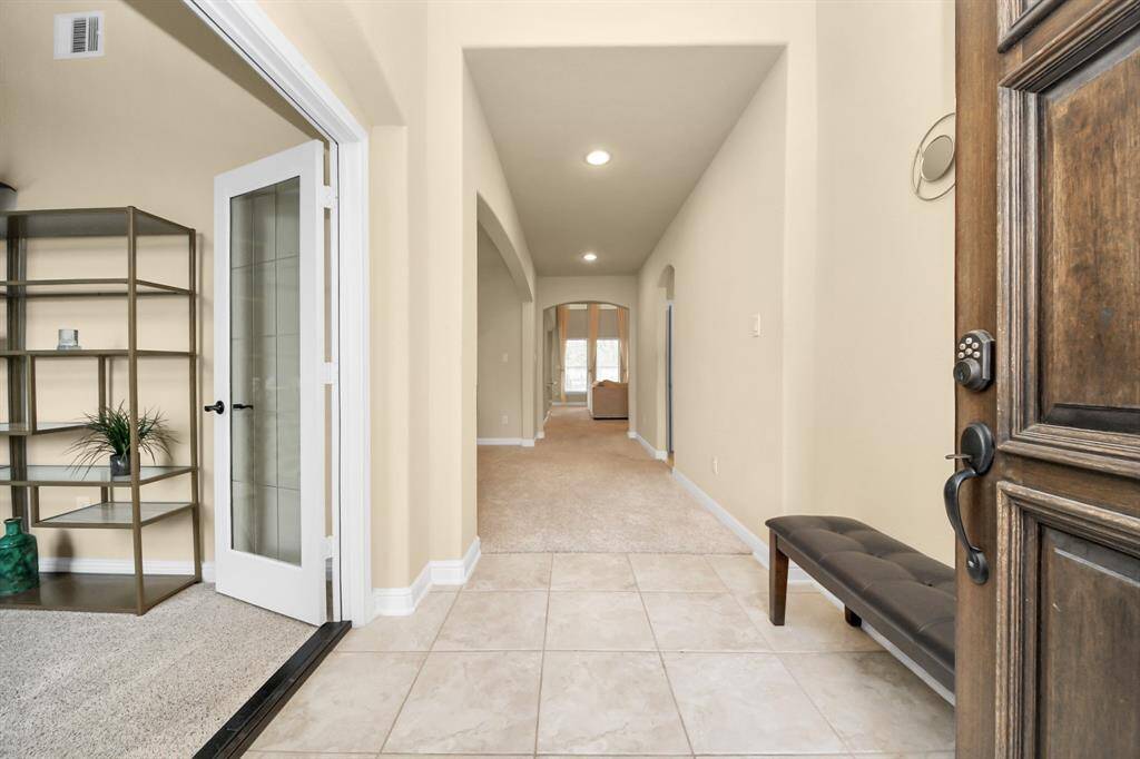 This entryway features a welcoming space with neutral walls and tiled flooring.