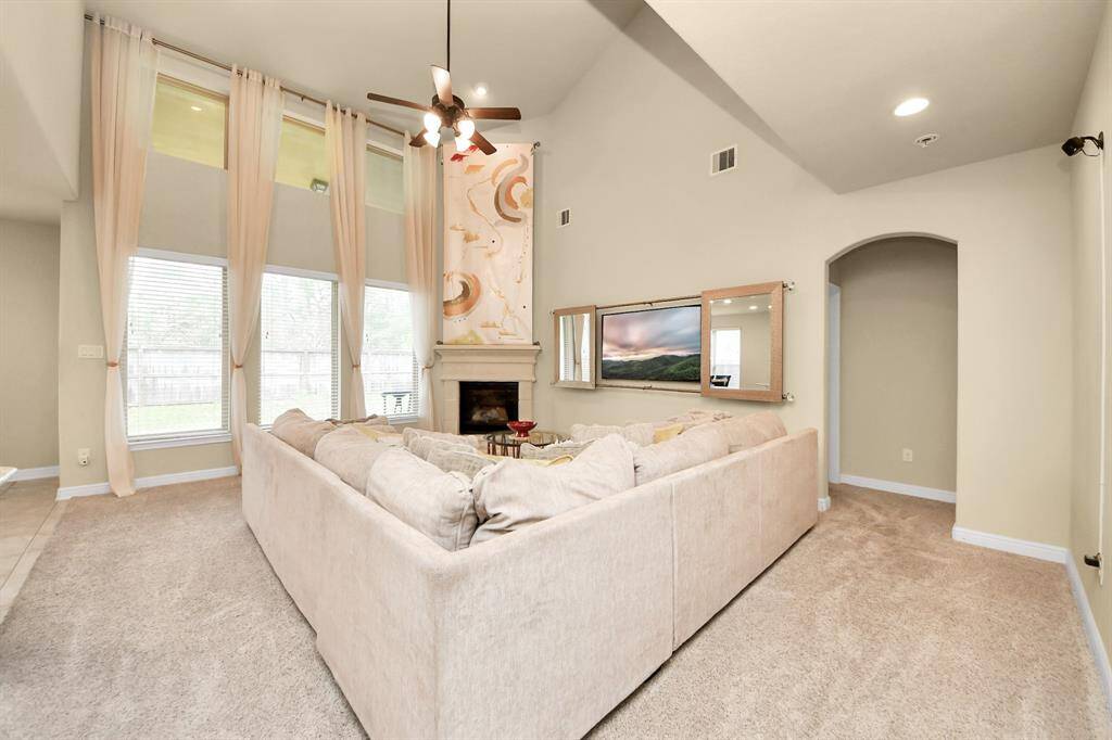 Comfy and stylish living room with a large sectional, a fireplace and a mounted TV.