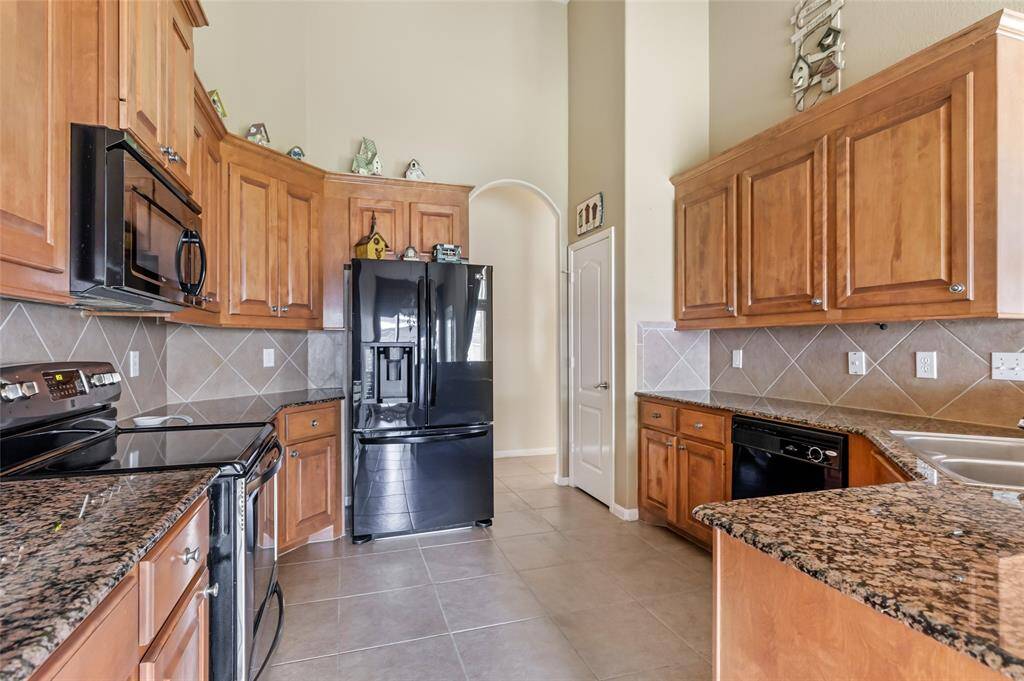 Elegant kitchen featuring sleek granite countertops and a spacious pantry for ample storage.