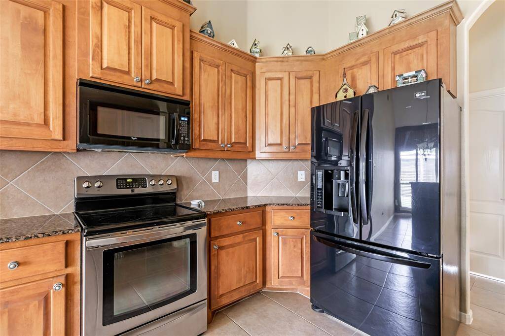Abundant cabinetry offers ample storage space, enhancing both functionality and style in this kitchen.