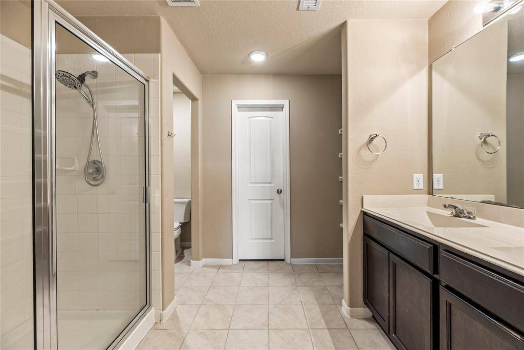 The primary bathroom is private and inviting, roomy enough to move around comfortably.