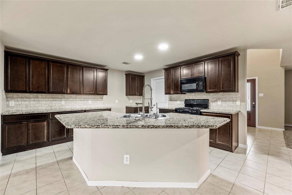 Your chef inspired kitchen awaits! Features include granite countertops paired with a coordinating tile backsplash, high end appliances, rich cabinets, recessed lighting, and a sprawling island with breakfast bar seating.