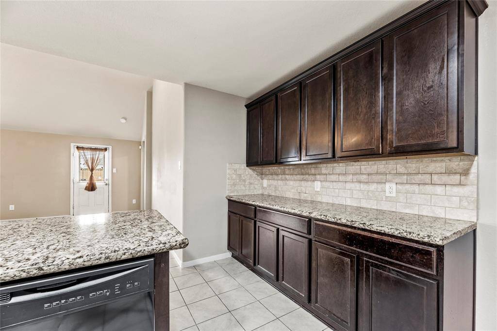 Granite countertops paired with a coordinating stone backsplash not only provide a durable and elegant surface for food preparation but also add a touch of luxury and sophistication to the kitchen.