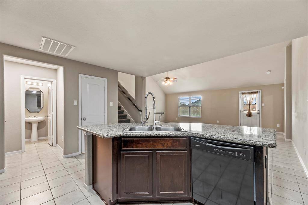 The sprawling island with breakfast bar seating serves as a versatile centerpiece, providing additional workspace, storage, and seating for casual dining or entertaining.