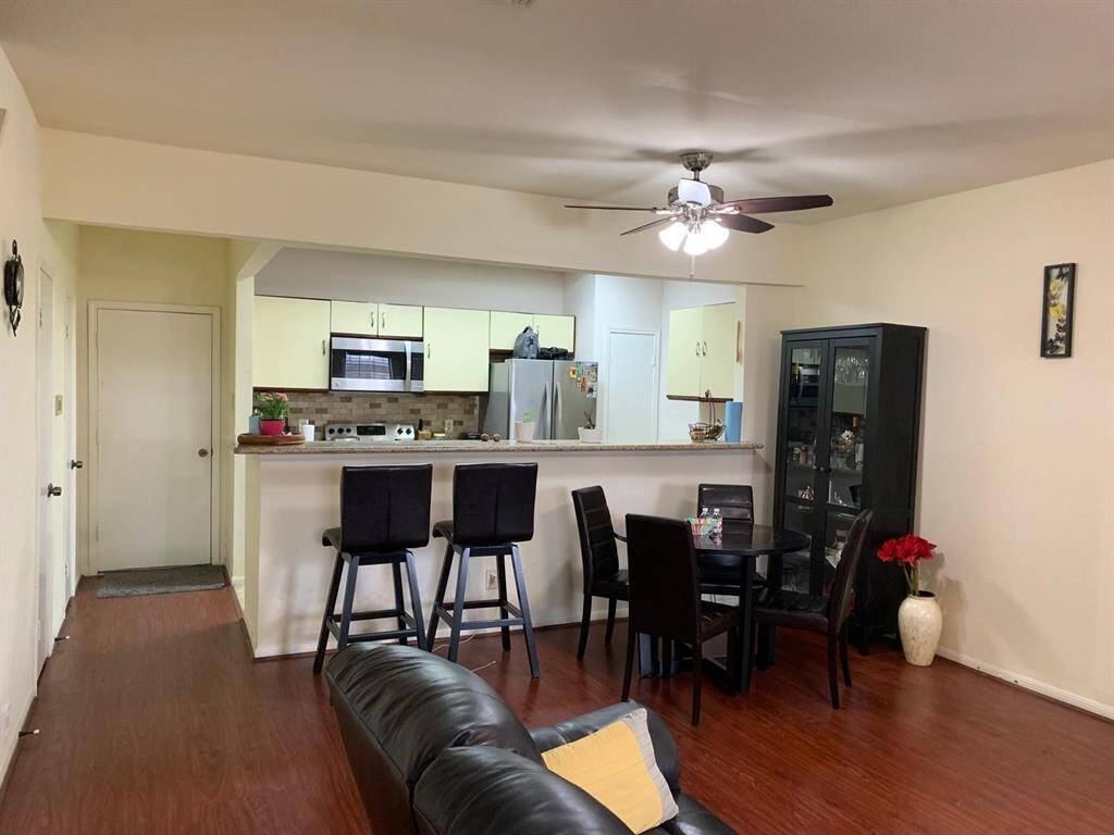 A Beautifully maintained space featuring a modern kitchen with stainless steel appliances, and a spacious breakfast bar perfect for entertaining. Warm wood flooring, a ceiling fan, and thoughtful layout make this home feel cozy and stylish.