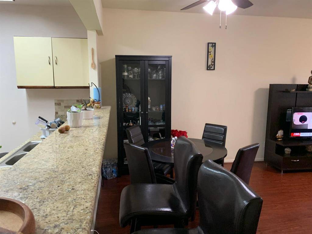 Enjoy meals and conversations in this cozy dining area, perfectly set next to a sleek granite breakfast bar and open kitchen. The warm-toned flooring, ample cabinet space, and open layout. A fantastic blend of comfort and convenience!