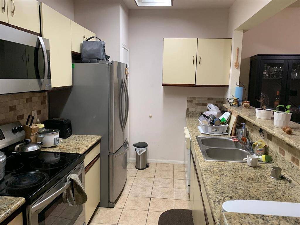 Featuring granite countertops, stainless steel appliances, and plenty of cabinet storage, this galley-style kitchen is as functional as it is stylish.
