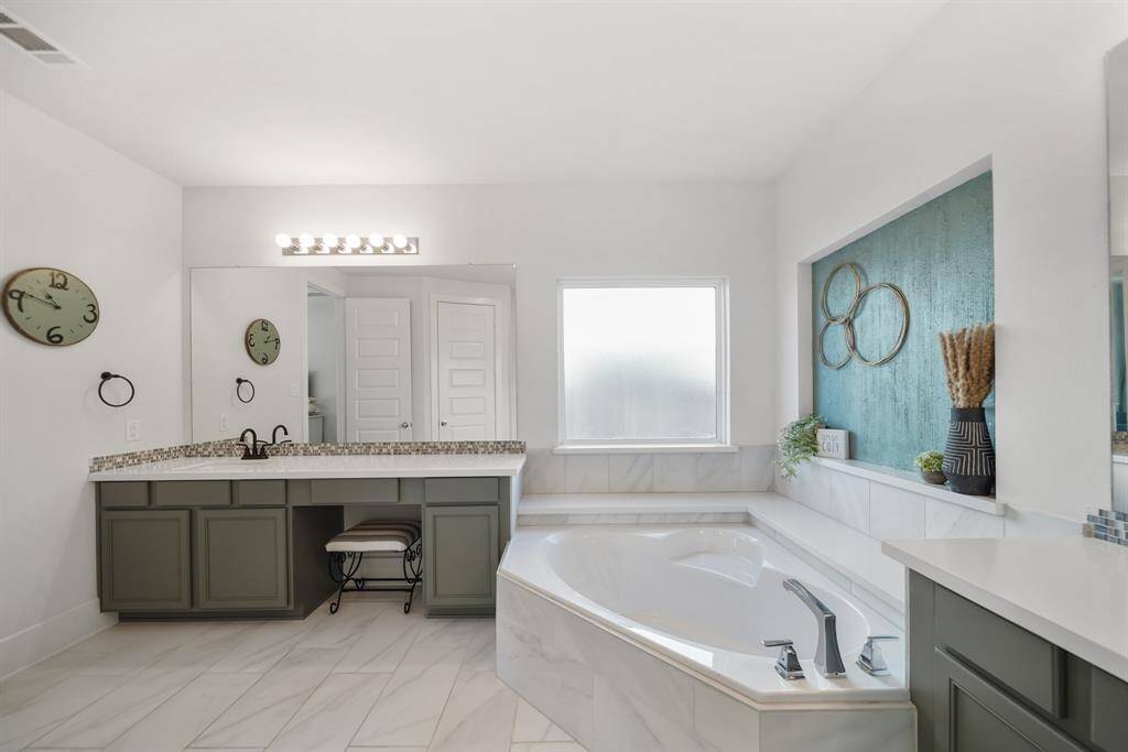 Luxurious primary bathroom featuring dual vanities with ample counter space, modern fixtures, and beautiful finishes for a spa-like retreat.