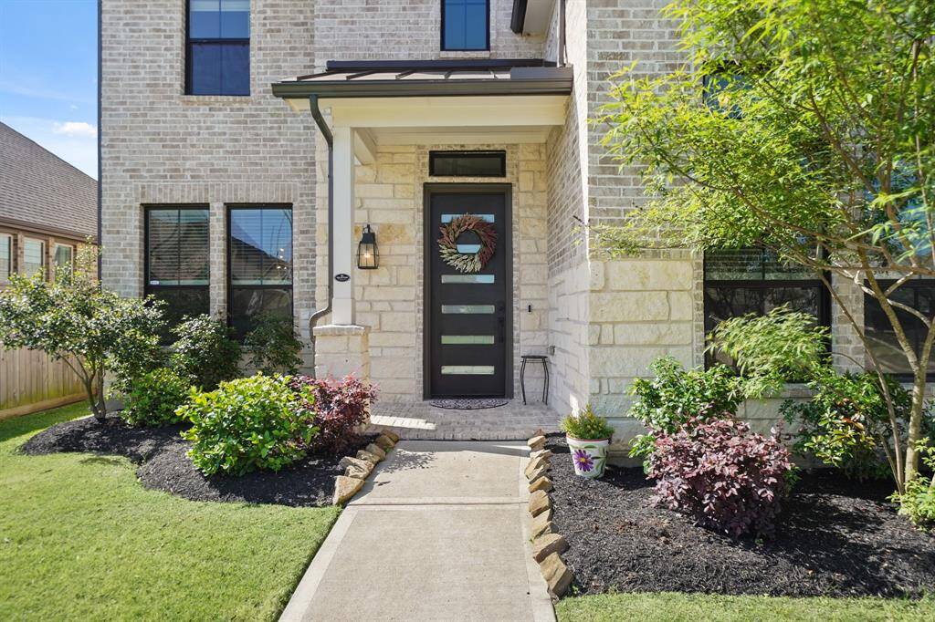 Close-up of the front facade showing the blend of stone and brickwork that adds character and timeless beauty to the home.