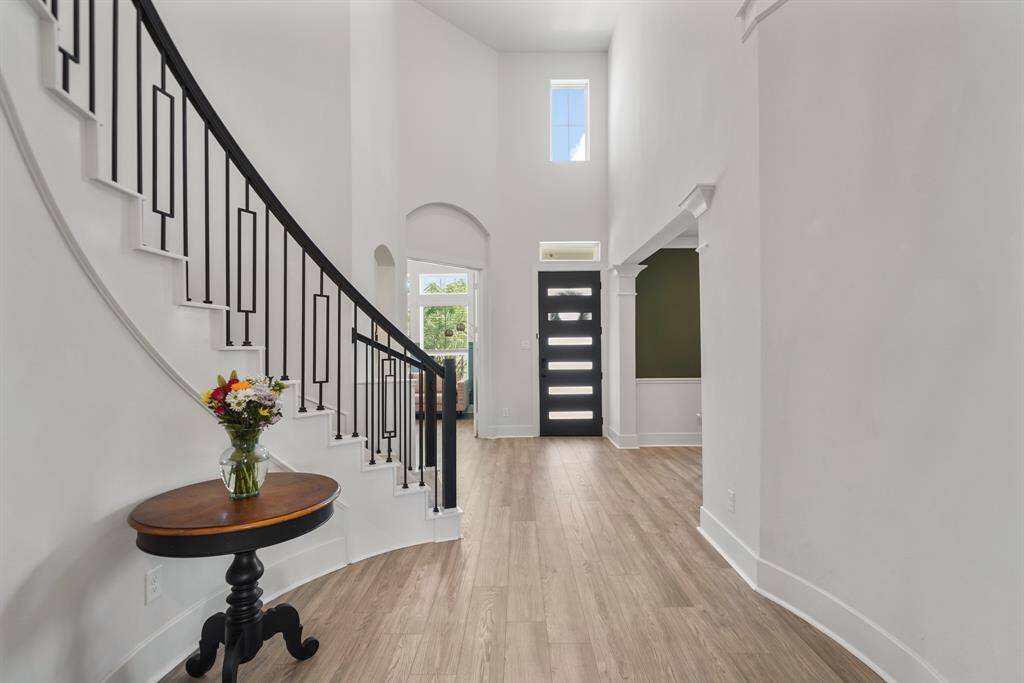 View of the sweeping spiral staircase with wrought iron railing.