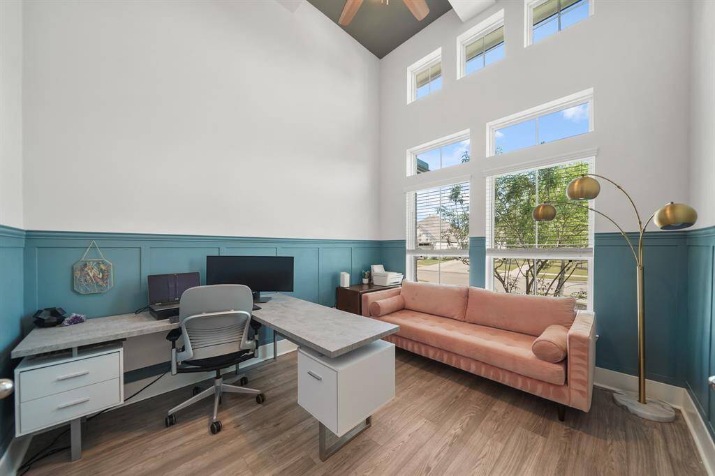 Private study featuring rich wainscoting and ample natural light.