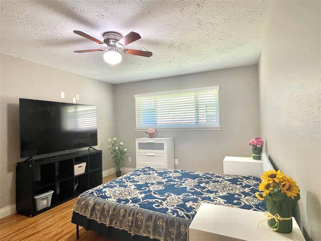 primary bedroom with queen size bed and  dresser, night stands