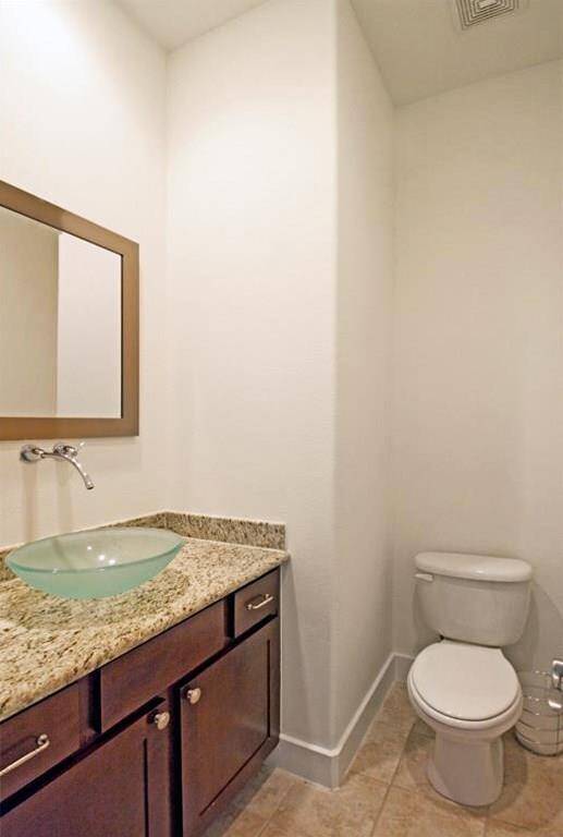 This half bathroom offers granite counters, wall mounted faucet, & bowl sink, and is located at the top of the stairs on the main living floor (2nd floor).