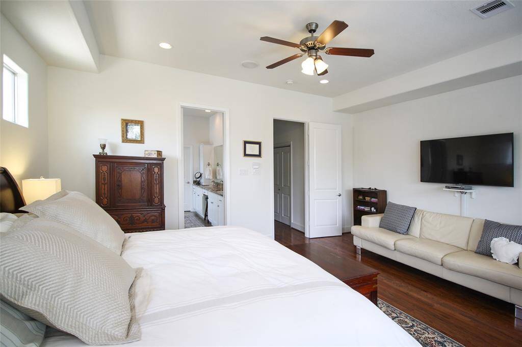 The primary easily accommodates a king bed, dual nightstands, a lounge area, and office space. TV Mount remains!