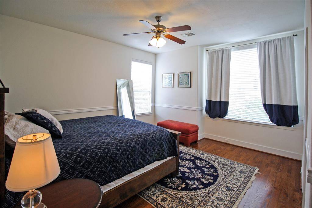 This is the secondary bedroom on the 3rd floor. Lovely millwork, even more natural light, hardwood floors, and private bathroom!