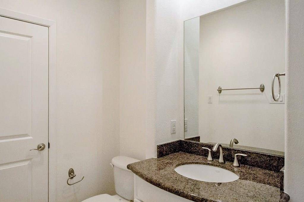This is the private bathroom to the first floor bedroom, with granite counters, built-in shelving, & walk-in closet.