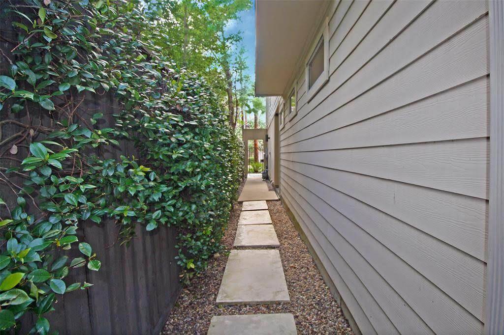 This is the walkway to the backyard. Notice the gated front entry. The front doors are to the right just past the windows.