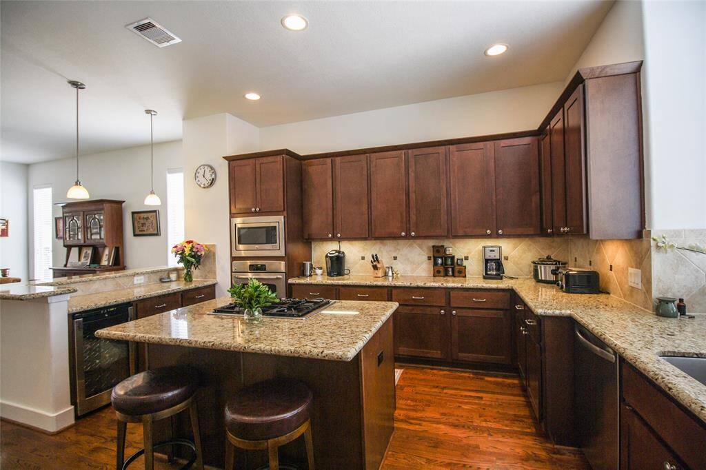 Look at all of the counter & prep space, plus wine fridge & under cabinet lighting!
