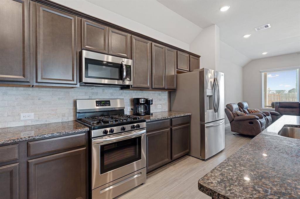 Nice set up for a gourmet chef with the gas burner stove top, range, tons of counterspace and cabinets along with an island with a single large deep sink.