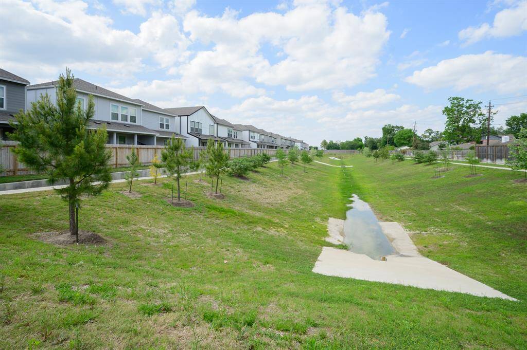 Enjoy easy access to a scenic walking trail right behind the property, surrounded by lush greenery and trees for a serene suburban experience.