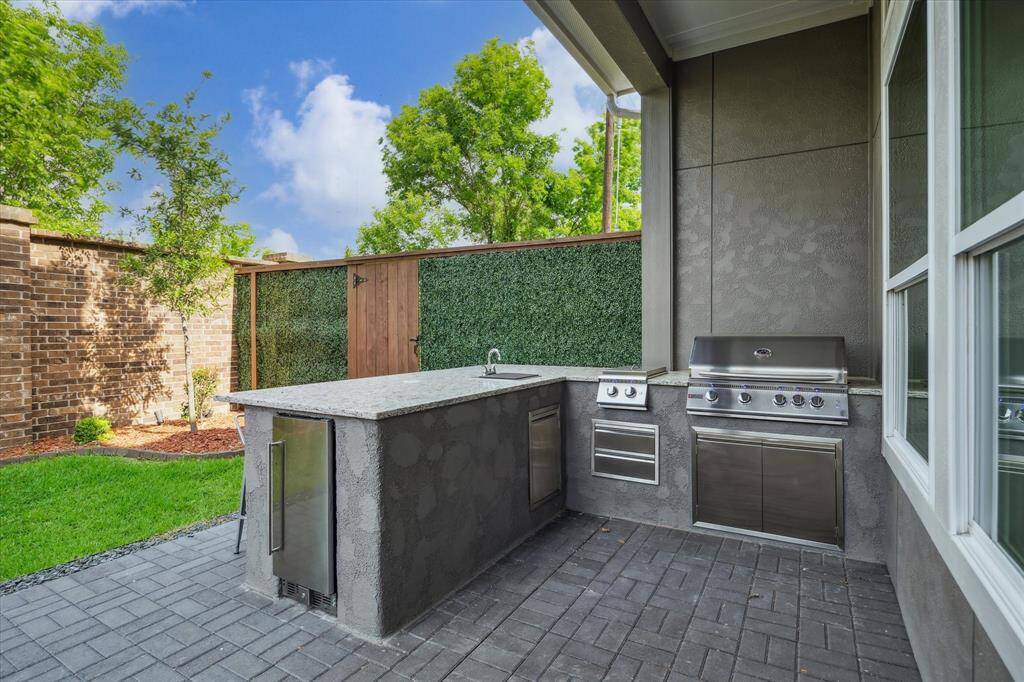 Luxury Outdoor Kitchen – Featuring gas grill, side burner, sink and refrigerator,perfect for entertaining.