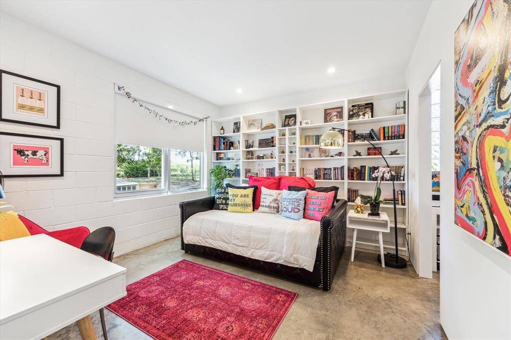 The adorable third bedroom features a wall of bookshelves, recessed lighting, direct access to the home office and shared guest bathroom.