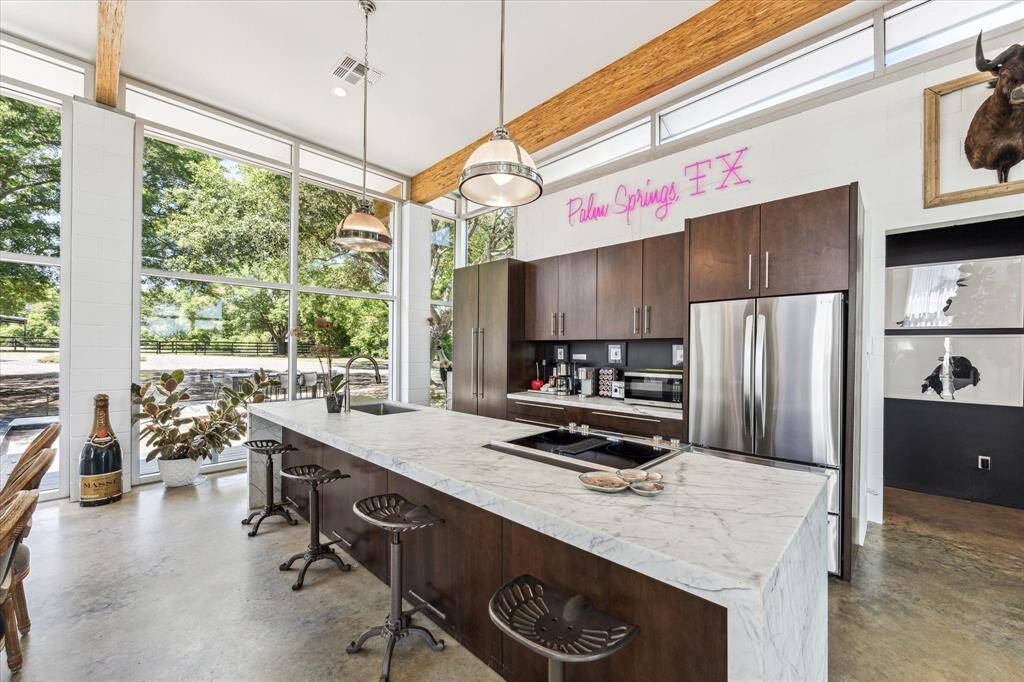 The huge island features a marble waterfall edge counter and Jenn Air range with convection & air fryer capabilities. Serving family and guests will be a breeze in this fabulous kitchen.