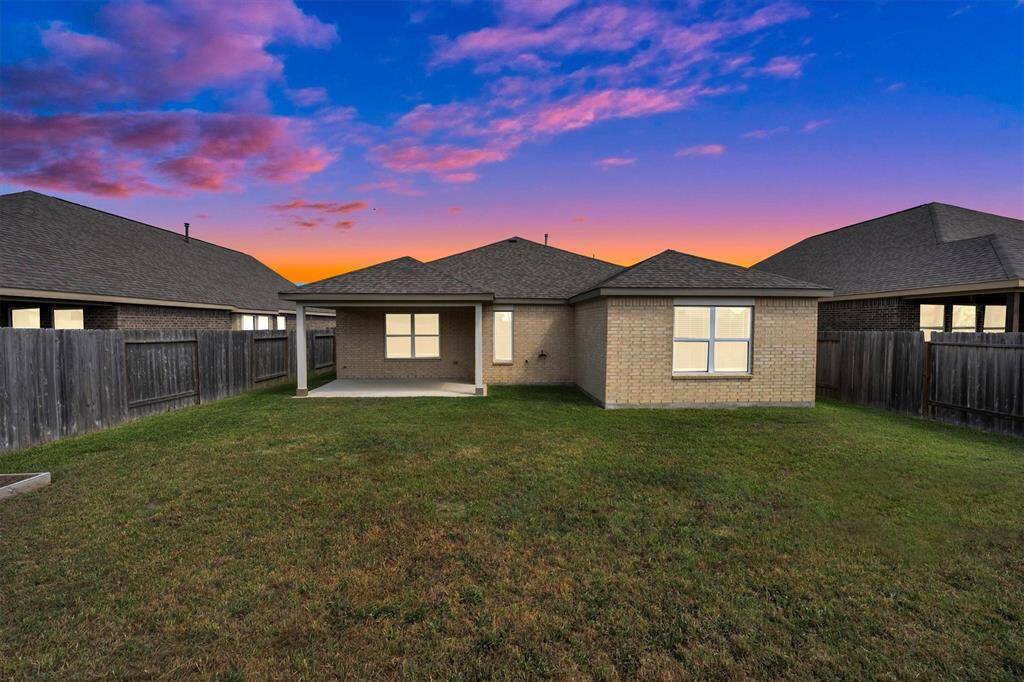Cozy brick home with a spacious backyard, featuring a covered patio. Fenced for privacy, perfect for outdoor relaxation. Beautiful sunset views complete the inviting atmosphere.
