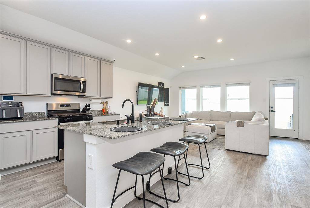 Designer painted cabinets in the kitchen with granite counters and stainless steel appliances