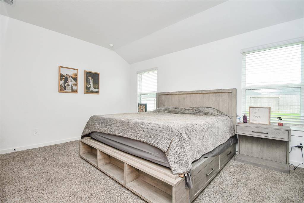 Spacious primary bedroom with elevated ceilings and natural light