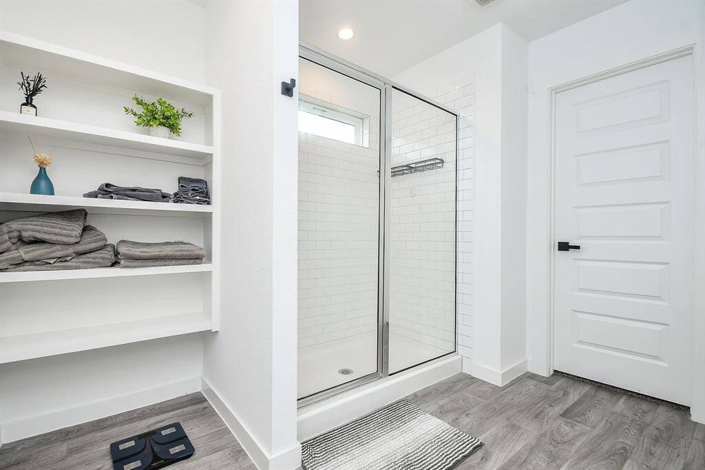 Large walk-in shower with tile surround and plenty of storage