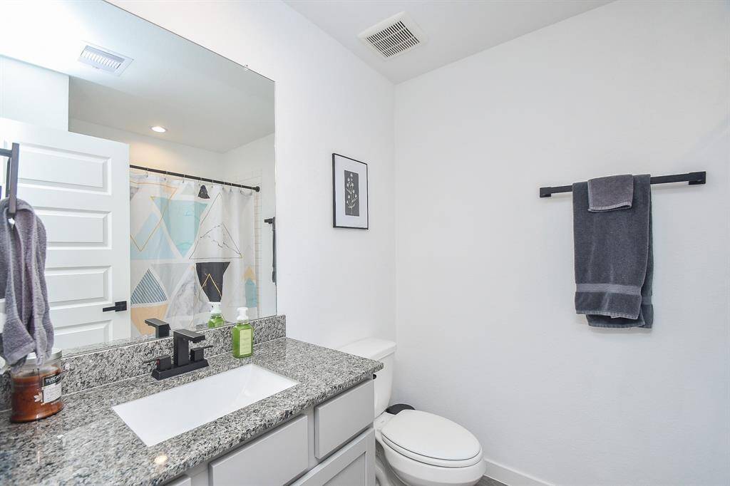 Secondary bath with granite counters and modern black fixtures