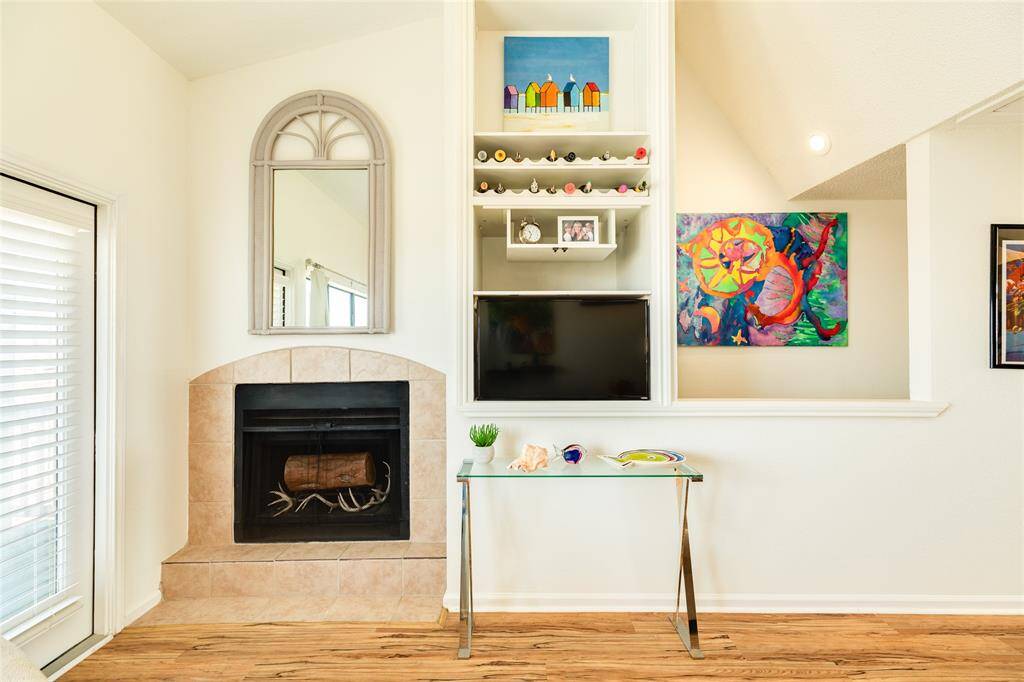 Another view of that cozy fireplace and custom built-in. The opening over the stairs offers a peek-a-boo to the level below.