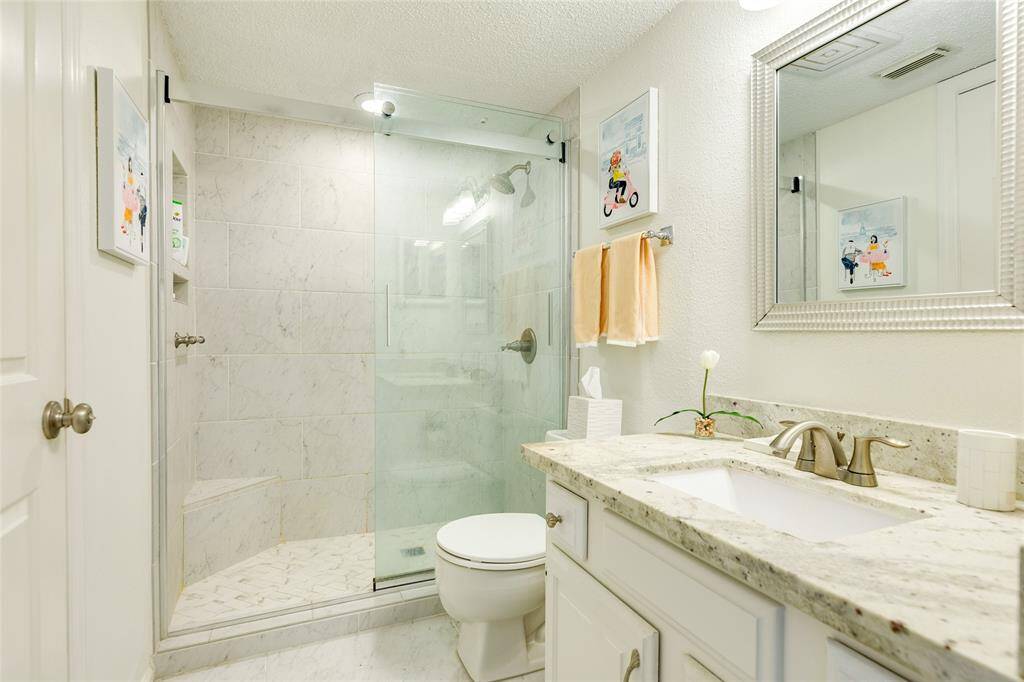 Leathered granite counters, marble tile floors and shower, custom sliding glass barn-style shower doors, and more. This Primary Bath will pamper you every time you're here.