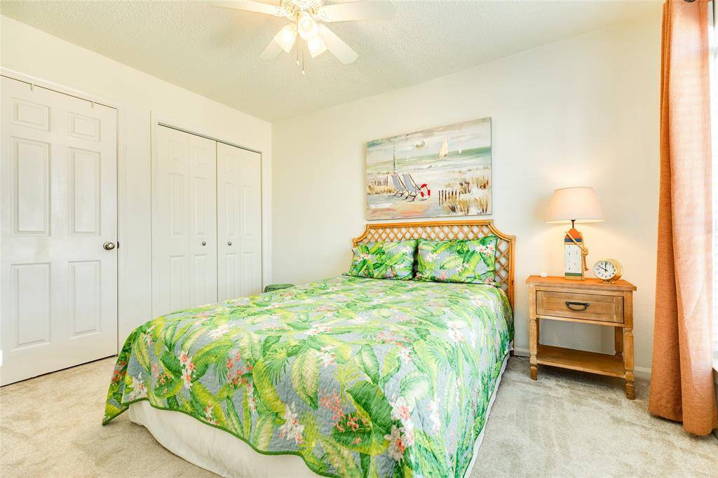 The secondary bedroom features a large built-in storage and display wall, two closets, high grade carpeting for maximum comfort, and a convertible option to become a family room.